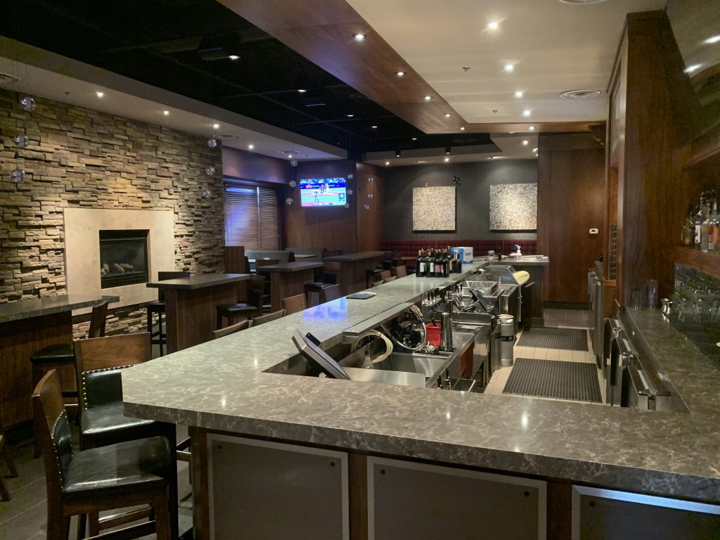 Multiple mounted televisions and installed lights in a restaurant and bar