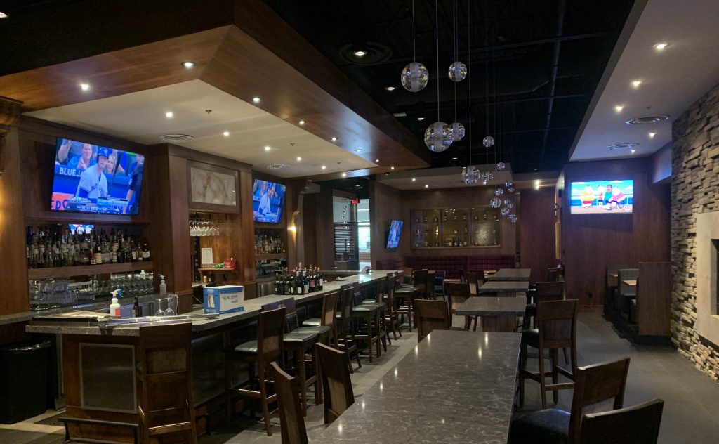 Multiple mounted televisions and installed lights in a restaurant and bar