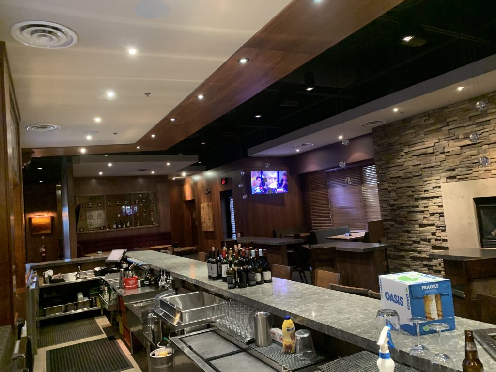 Multiple mounted televisions and installed lights in a restaurant and bar