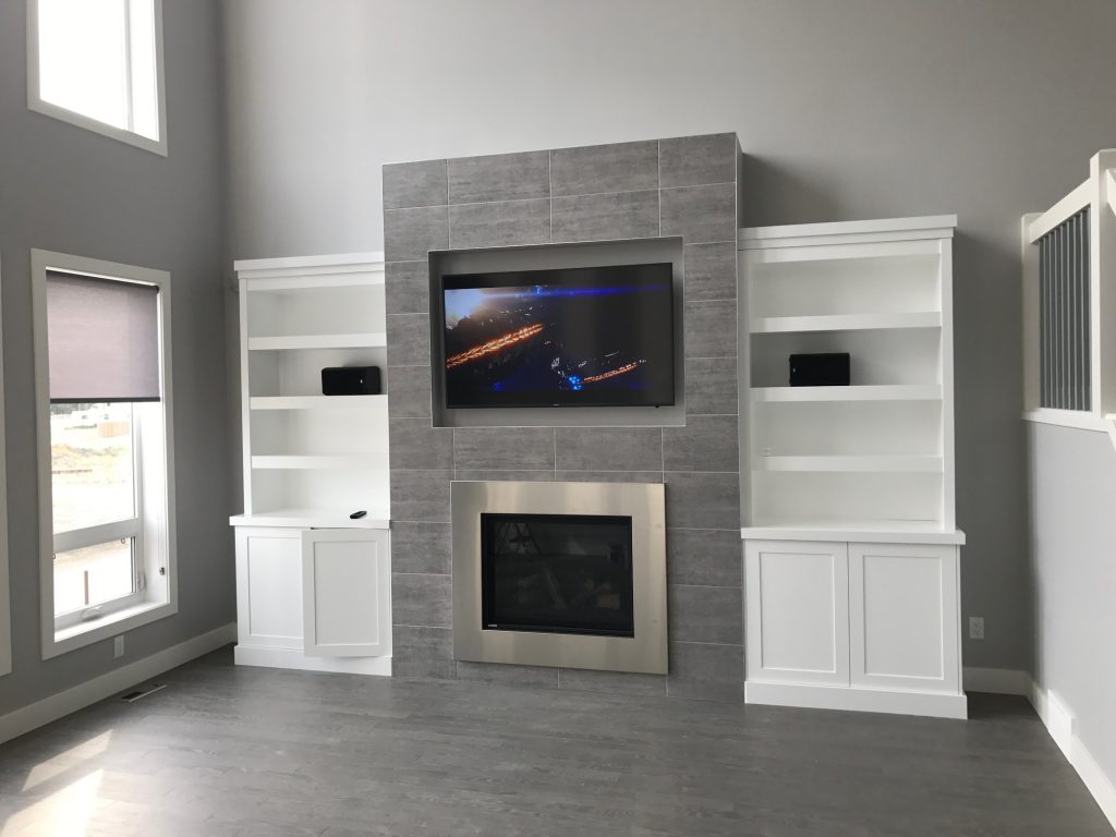 mounted television above a chrome fireplace in a bright room