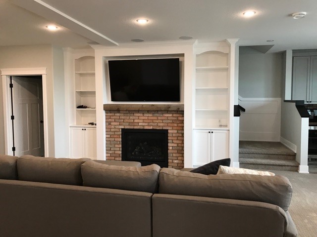 Mounted tv above a fireplace in the basement